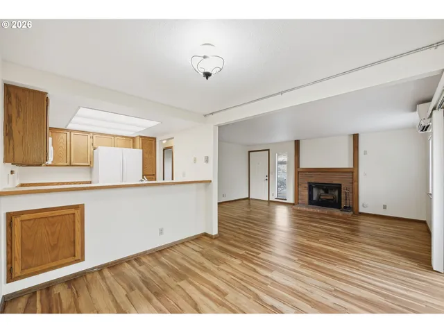 a view of empty room with wooden floor and fireplace