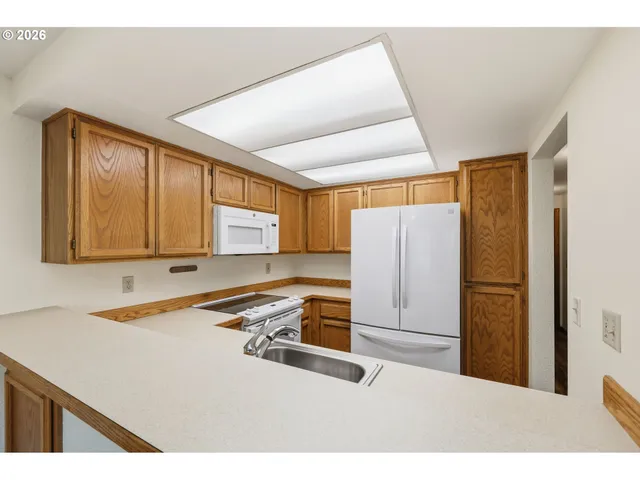 a kitchen with a refrigerator sink and cabinets