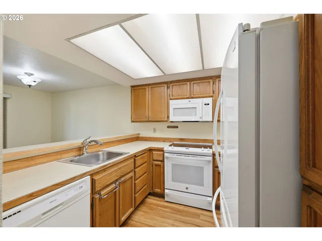a kitchen with a sink cabinets stainless steel appliances and a window