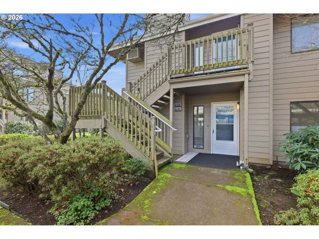 a view of a house with brick walls and a yard with potted plants