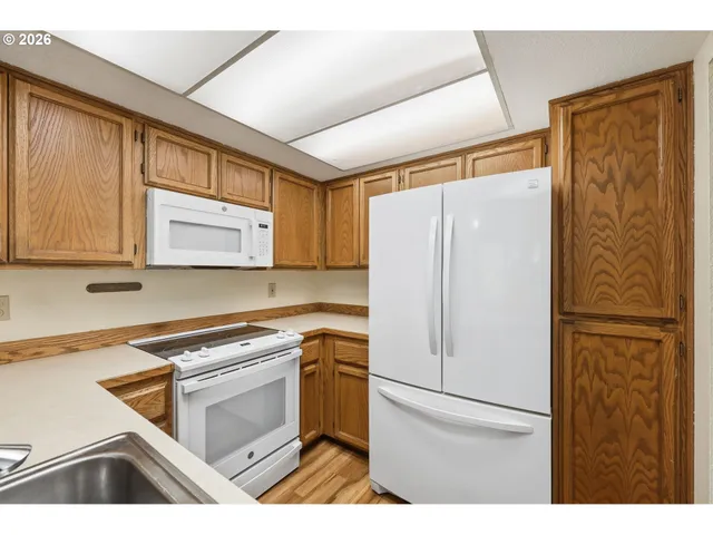 a kitchen with a refrigerator a stove top oven and cabinets