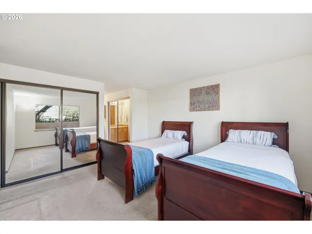 a bedroom with two beds and a large mirror