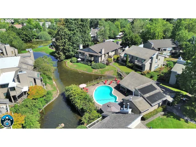 an aerial view of a house with a garden and lake view