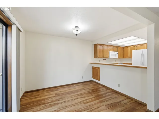 a view of a kitchen with wooden floor and a window