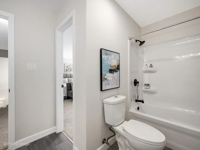 a white toilet sitting next to a bath tub