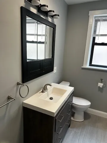 a bathroom with a sink mirror and toilet