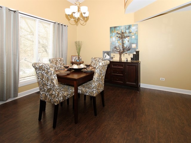 8819 Gardner Road Fox River Grove, IL 60021 - Photo 9 of 24 a dining room with furniture a chandelier and wooden floor