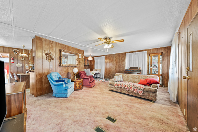 49 600 North Hurricane, UT 84737 - Photo 2 of 33 Carpeted living area with wooden walls, ceiling fan, and a textured ceiling