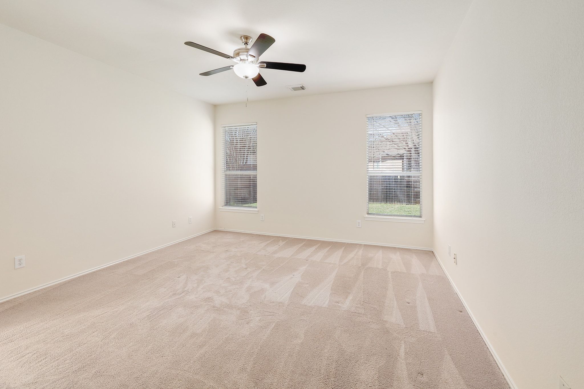 2307 Hayfield Square Pflugerville, TX 78660 - Photo 19 of 40 an empty room with windows and fan