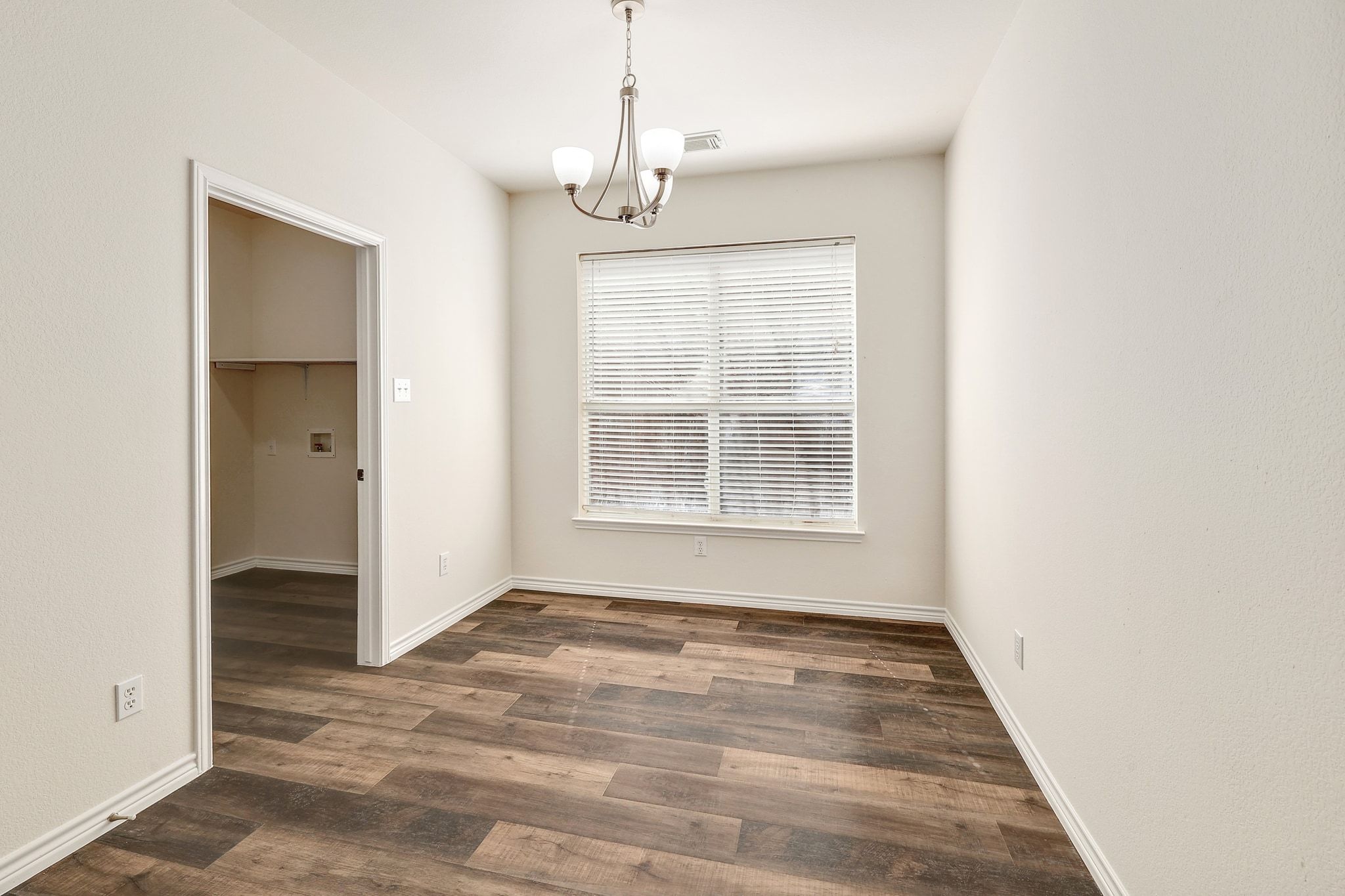 2307 Hayfield Square Pflugerville, TX 78660 - Photo 9 of 40 an empty room with wooden floor cabinet and windows