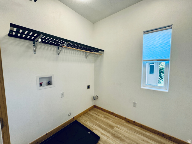 150 North 3050 East, Unit 4 St. George, UT 84790 - Photo 12 of 24 Utility room featuring wood-finish flooring, a wall-mounted shelving unit with a hanging rod, and a window with a cellular shade