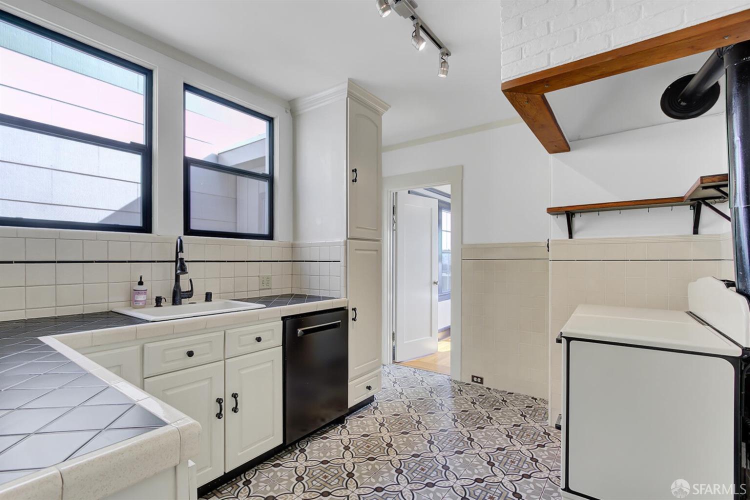 3927 Clement Street San Francisco, CA 94121 - Photo 24 of 72 a kitchen with a sink a refrigerator and a stove