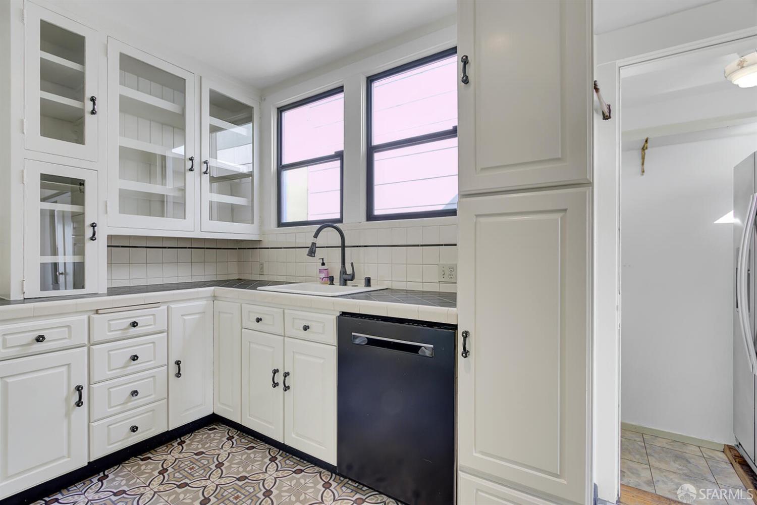 3927 Clement Street San Francisco, CA 94121 - Photo 27 of 72 a kitchen with a sink window and cabinets