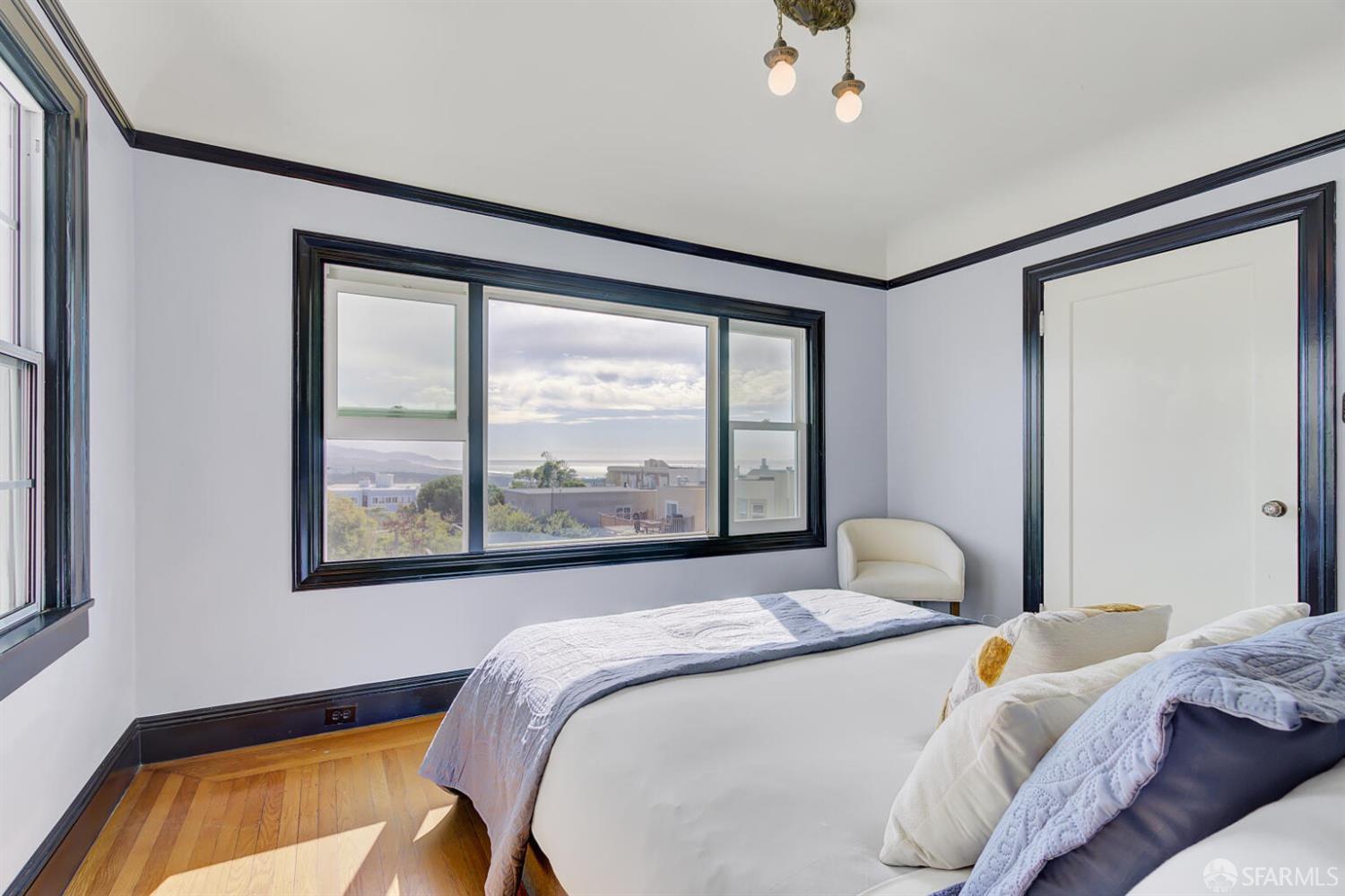 3927 Clement Street San Francisco, CA 94121 - Photo 31 of 72 a bedroom with a bed and a large window with outer view