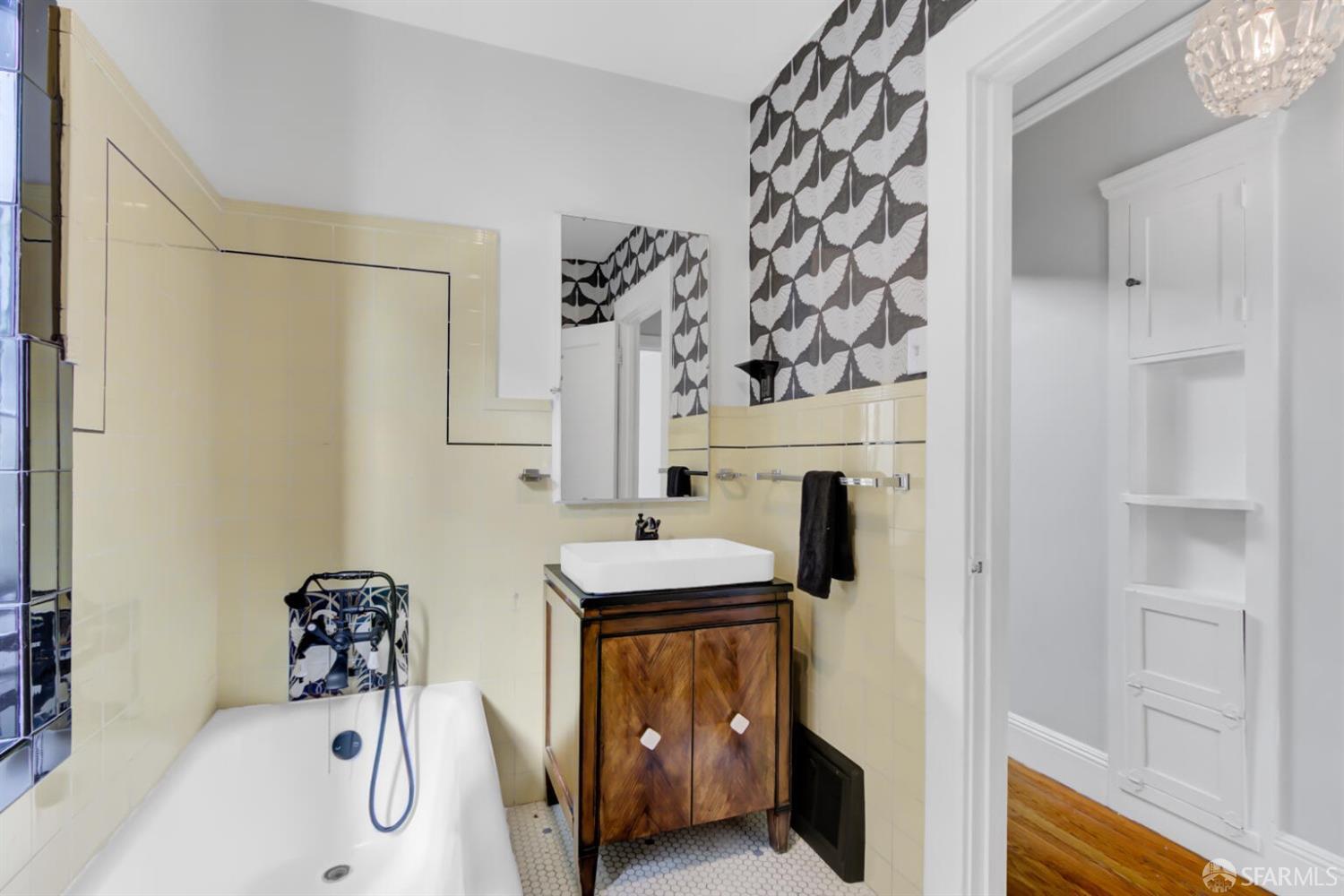 3927 Clement Street San Francisco, CA 94121 - Photo 36 of 72 a bathroom with a sink and mirror with bathtub