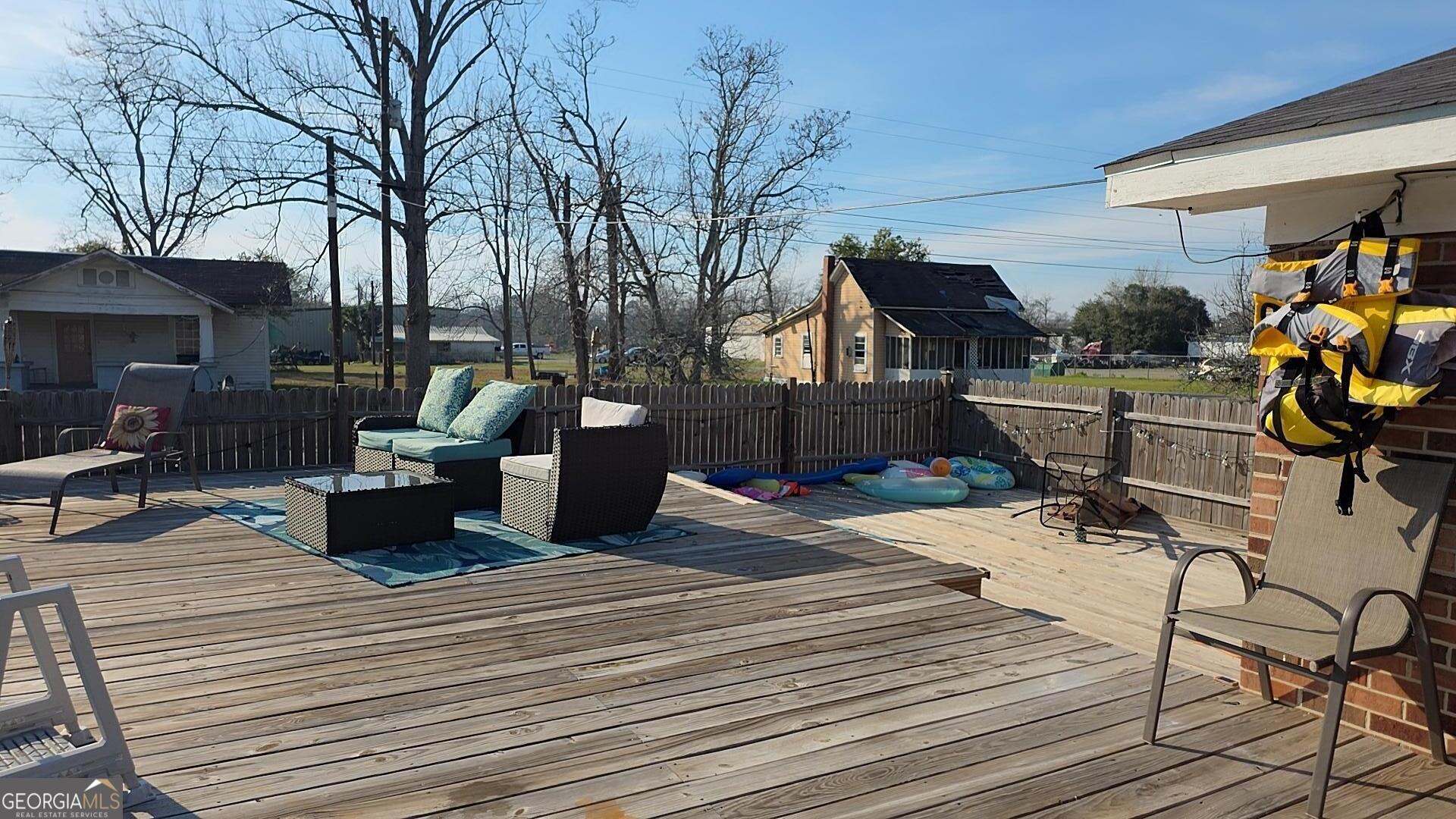 293 Williams Street Northeast Pelham, GA 31779 - Photo 13 of 19 a view of a patio with dining table and chairs with wooden floor and fence