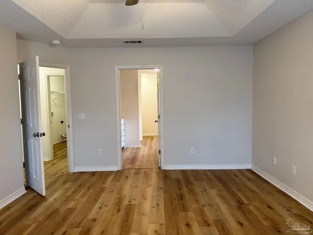 an empty room with wooden floor and entrance