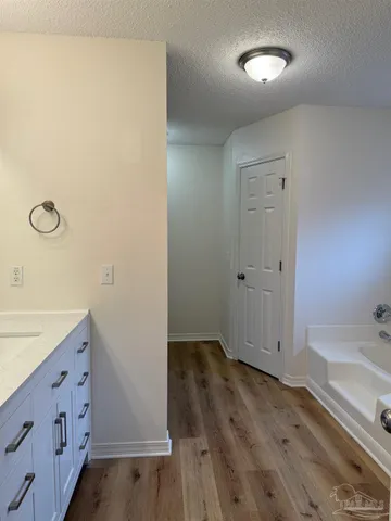 an empty room with wooden floor and mirror