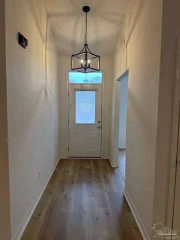 a view of a hallway with wooden floor and a window