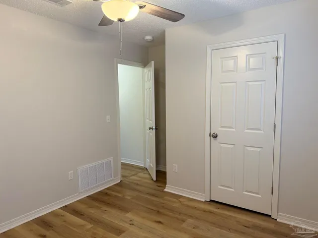 an empty room with wooden floor and closet