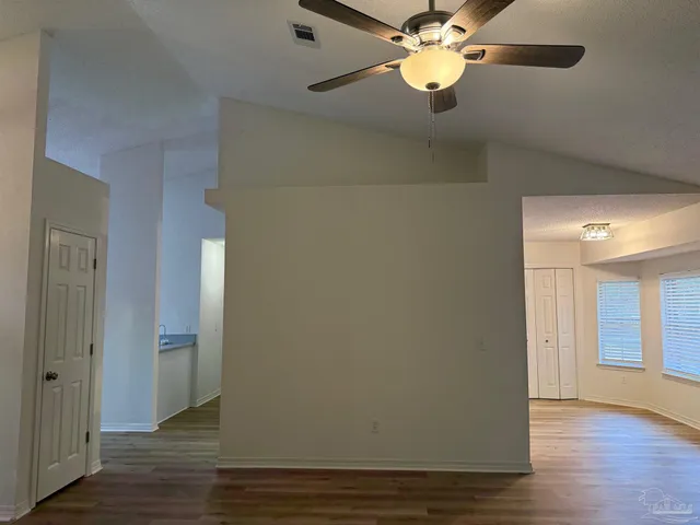 a view of an empty room with wooden floor
