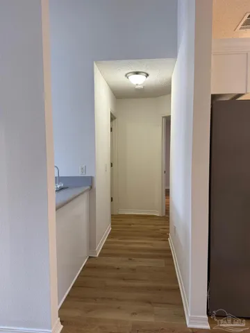 a view of a hallway with wooden floor