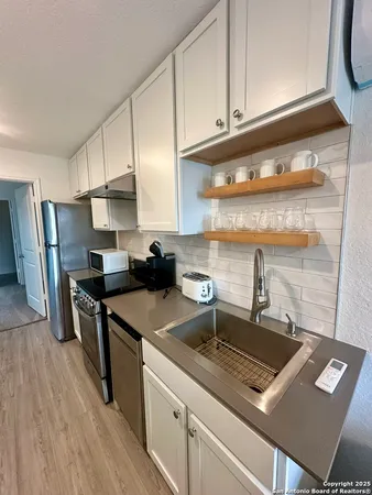 a kitchen with a sink a stove a refrigerator and cabinets