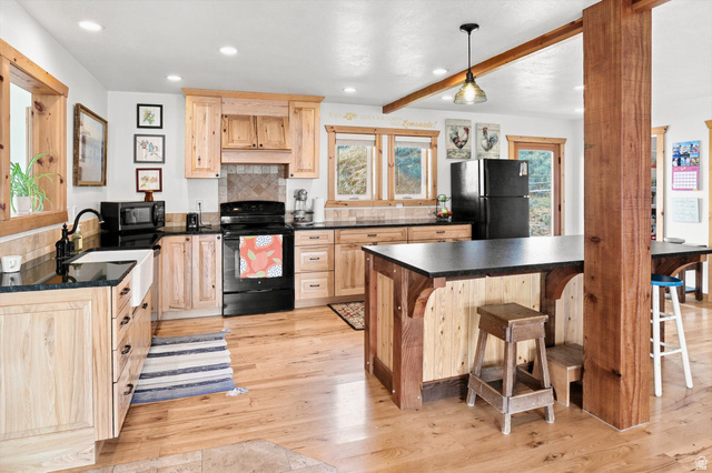 715 Ranch Loop Road Preston, ID 83263 - Photo 13 of 77 Kitchen featuring wood cabinetry, black countertops, and wood-finish flooring