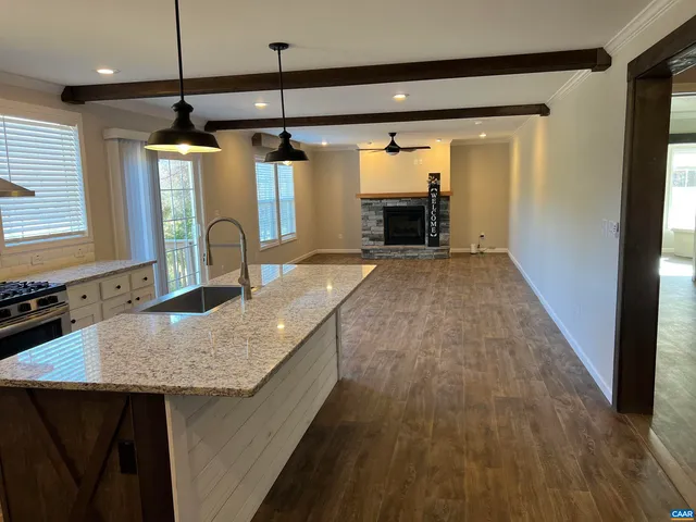 a kitchen with kitchen island a counter top space a sink a window and stainless steel appliances