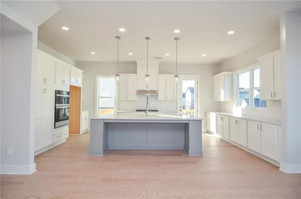 a kitchen with kitchen island a sink stainless steel appliances and cabinets
