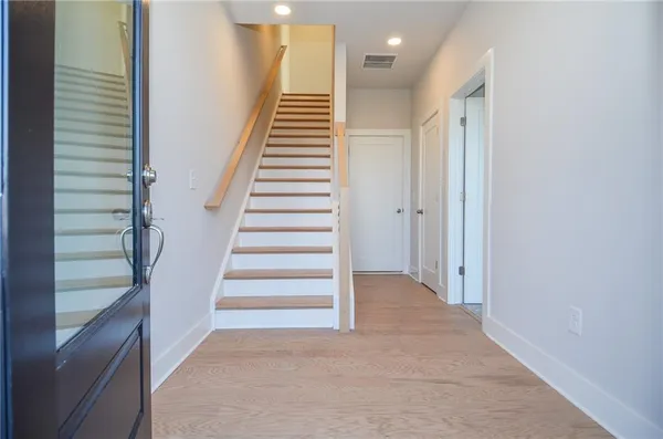 a view of entryway and hall with wooden floor