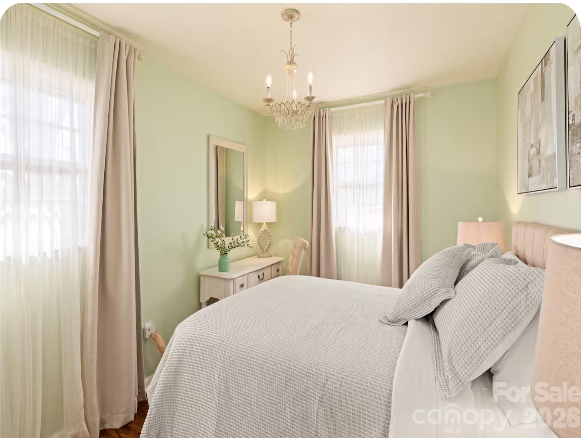 502 Long Shoals Road Arden, NC 28704 - Photo 15 of 32 a bedroom with a bed and a chandelier