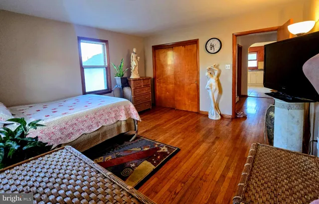 a bedroom with bed and wooden floor