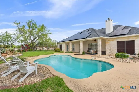 a view of a house with swimming pool and a yard
