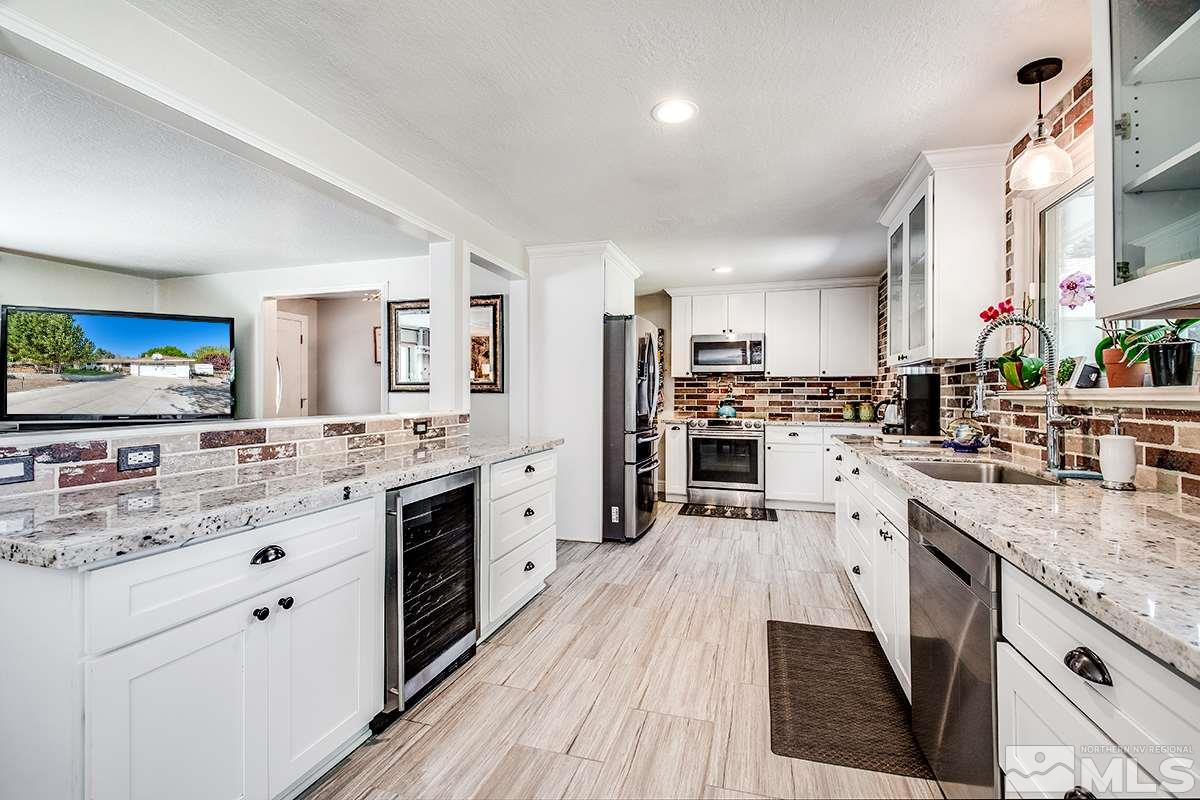 13805 Virginia Foothills Drive Reno, NV 89521 - Photo 11 of 25 a large kitchen with stainless steel appliances kitchen island granite countertop a large counter top and sink