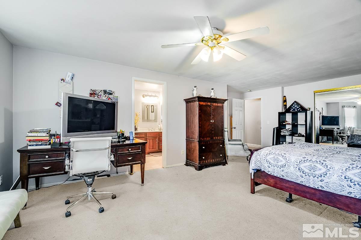 13805 Virginia Foothills Drive Reno, NV 89521 - Photo 20 of 25 a bedroom with a bed and a flat tv screen on wall