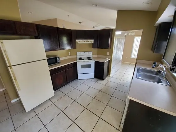 a kitchen with a sink a stove top oven and cabinets