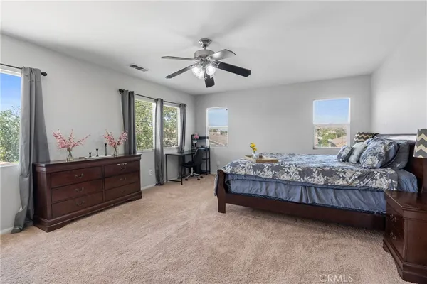 a spacious bedroom with a bed and a dresser