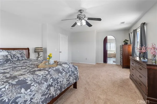 a bedroom with a bed and ceiling fan