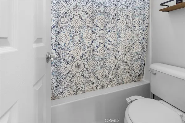 a bathroom with a toilet and a shower curtain