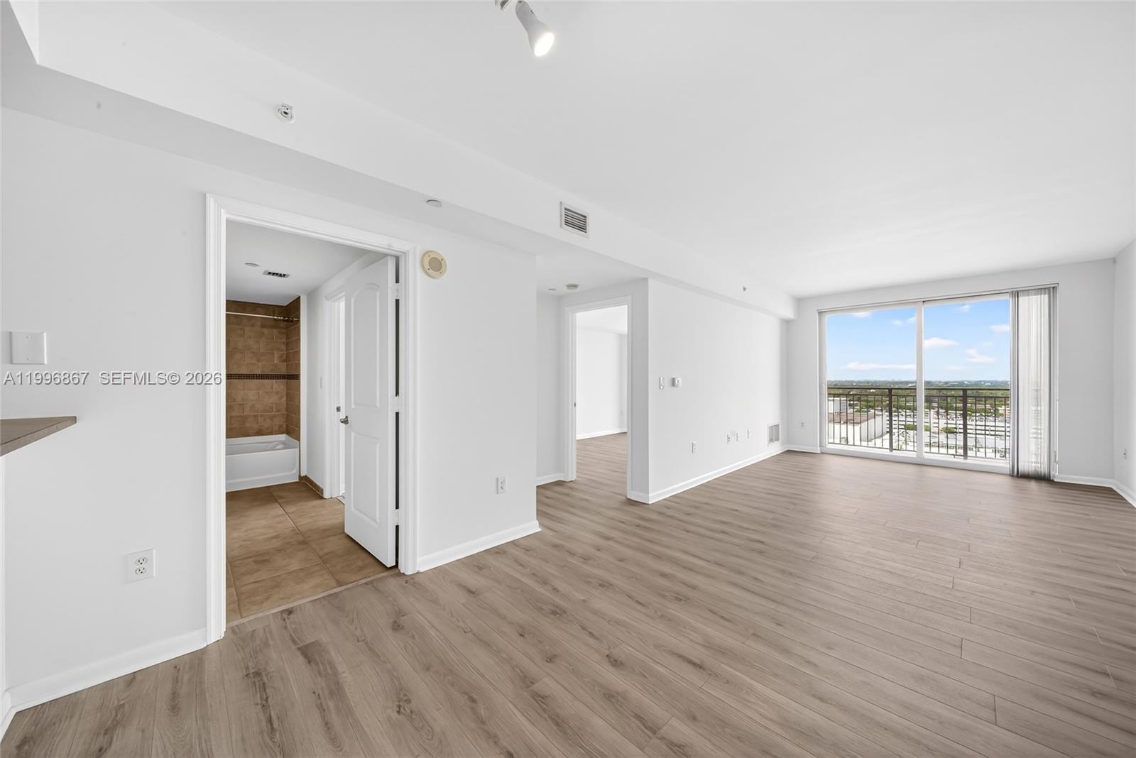 7350 Southwest 89th Street, Unit 1703S Miami, FL 33156 - Photo 1 of 29 an empty room with wooden floor and windows