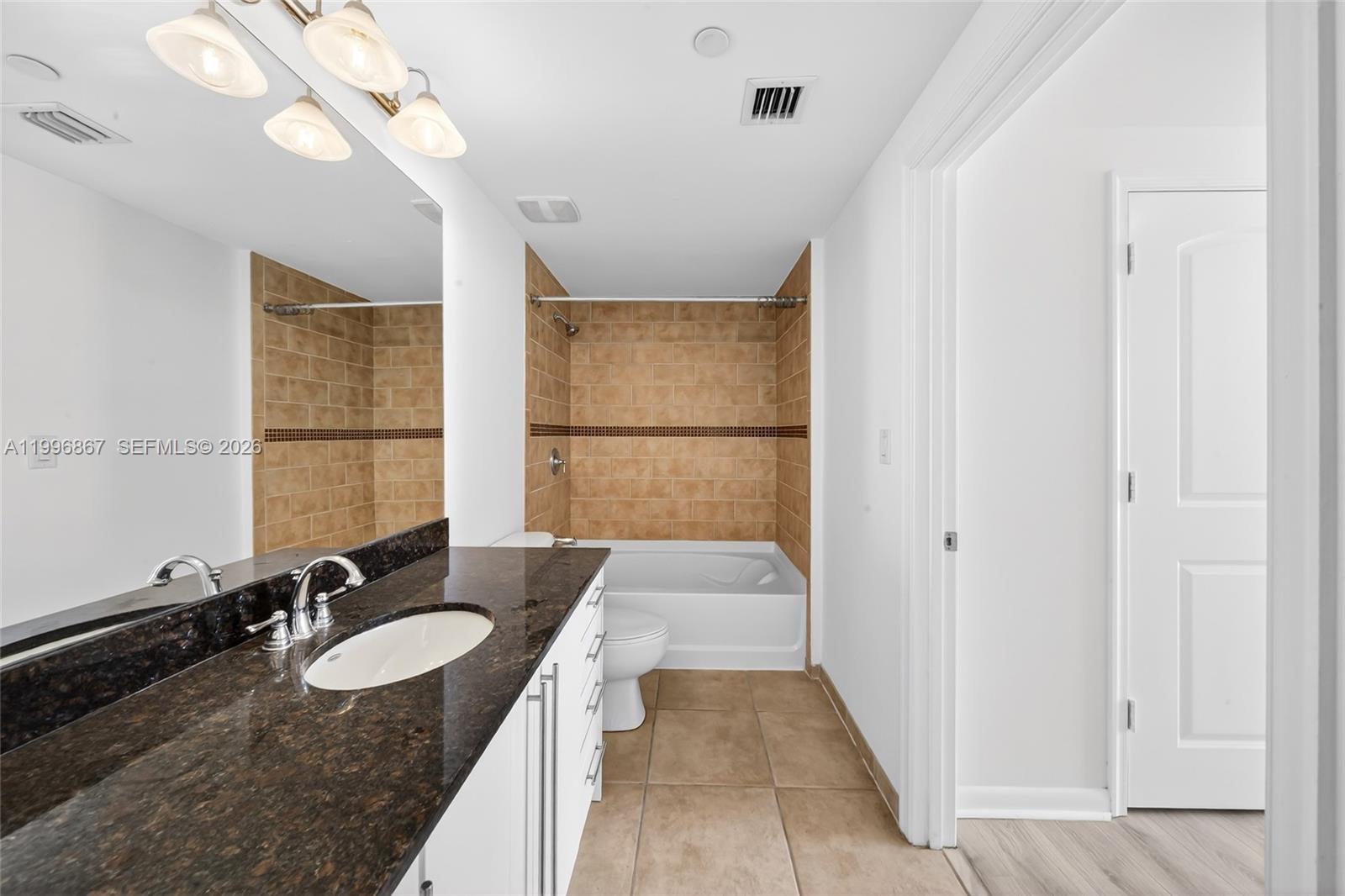 7350 Southwest 89th Street, Unit 1703S Miami, FL 33156 - Photo 14 of 29 a bathroom with a granite countertop sink and a mirror