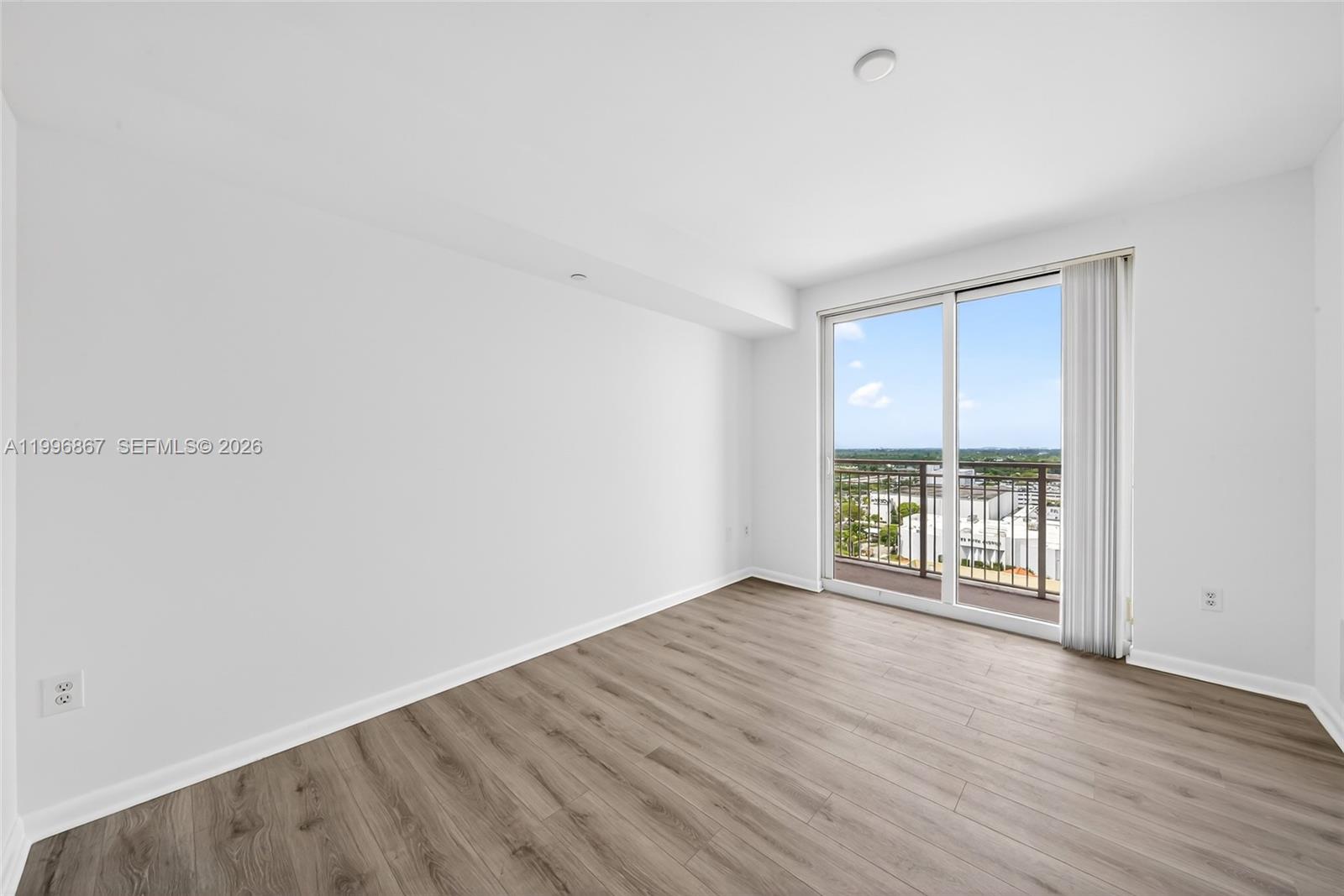 7350 Southwest 89th Street, Unit 1703S Miami, FL 33156 - Photo 18 of 29 an empty room with wooden floor and windows