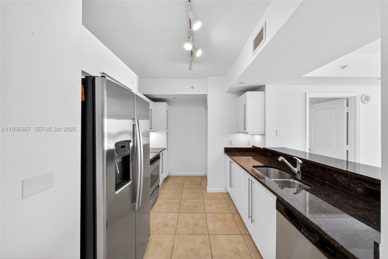 7350 Southwest 89th Street, Unit 1703S Miami, FL 33156 - Photo 3 of 29 a kitchen with granite countertop a refrigerator and a stove top oven