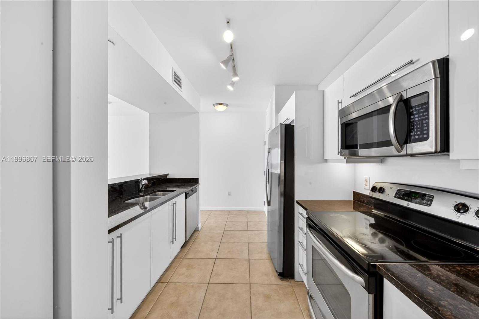 7350 Southwest 89th Street, Unit 1703S Miami, FL 33156 - Photo 4 of 29 a kitchen with stainless steel appliances granite countertop a stove and a microwave
