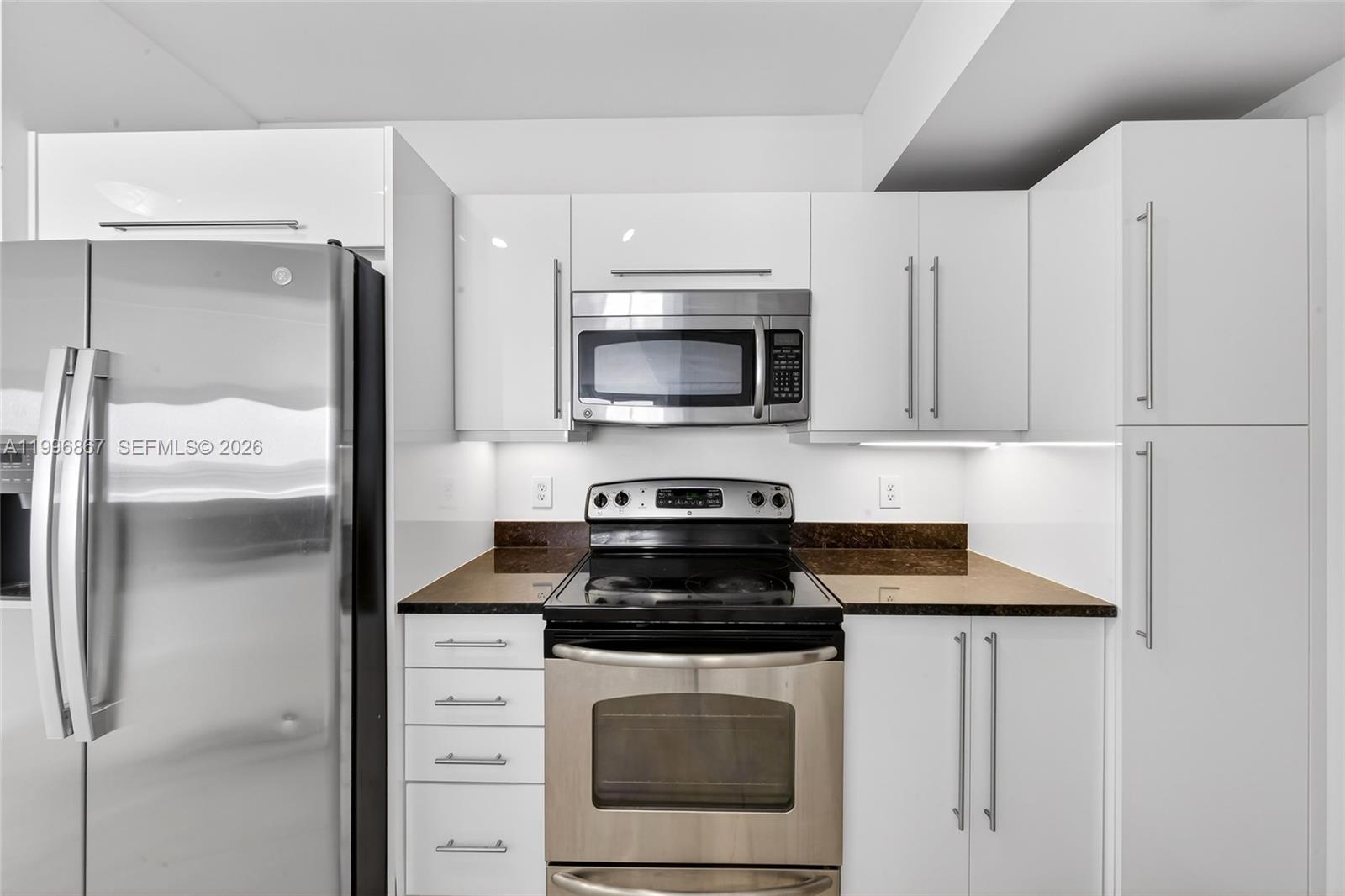 7350 Southwest 89th Street, Unit 1703S Miami, FL 33156 - Photo 5 of 29 a kitchen with stainless steel appliances granite countertop a stove a refrigerator and a microwave