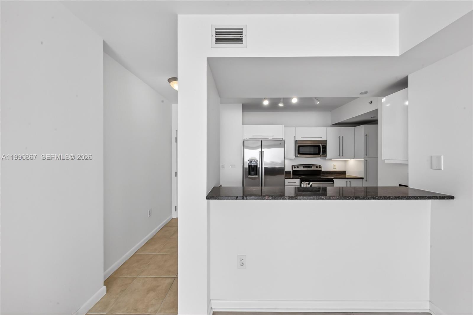 7350 Southwest 89th Street, Unit 1703S Miami, FL 33156 - Photo 8 of 29 a view of a kitchen with kitchen island a counter top space a sink and appliances