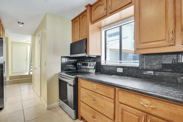 a kitchen with granite countertop a sink stainless steel appliances a counter space and cabinets