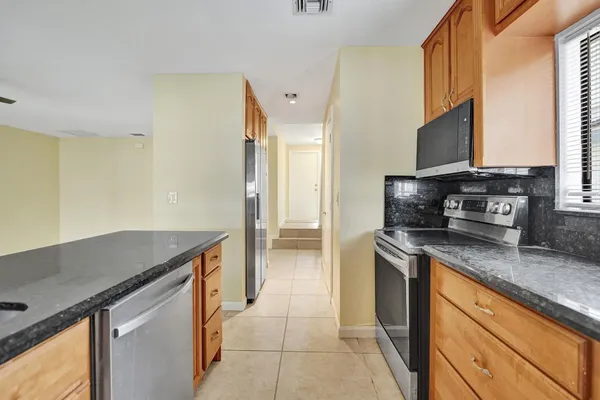 a kitchen with stainless steel appliances granite countertop a sink stove and refrigerator