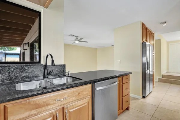 a kitchen with granite countertop a sink and cabinets